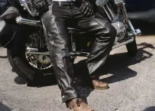 Person wearing leather pants sitting on a motorcycle