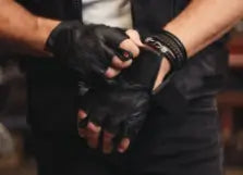 Person wearing black leather gloves and holding hands together with a blurred background